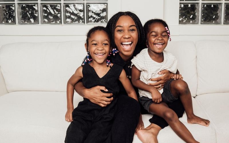 a woman sitting on a couch with two kids