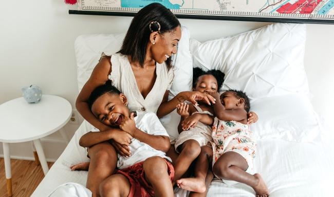 a woman on a bed with her children