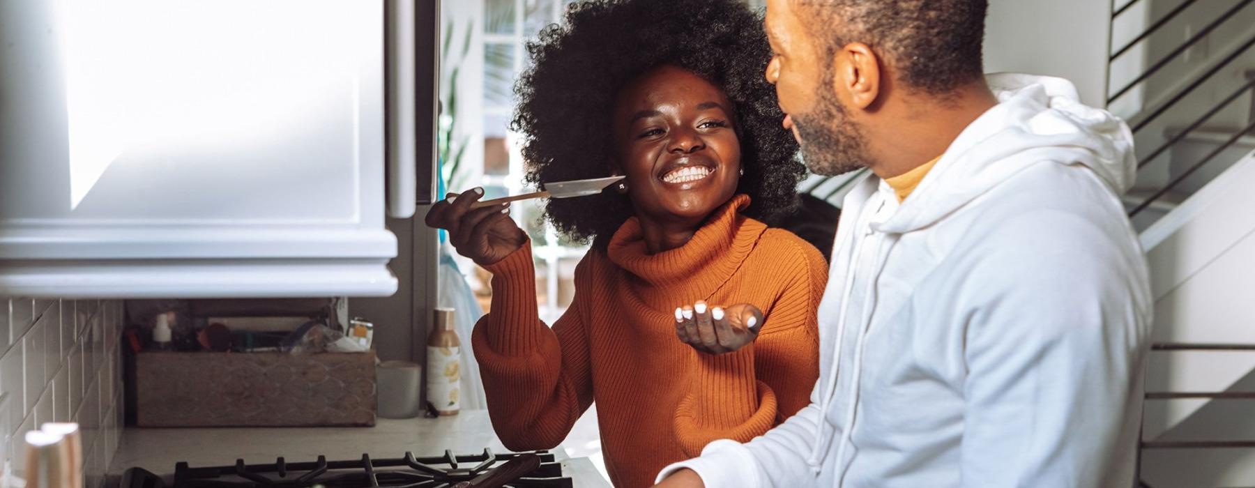 a man and a woman cooking on a gas stove top